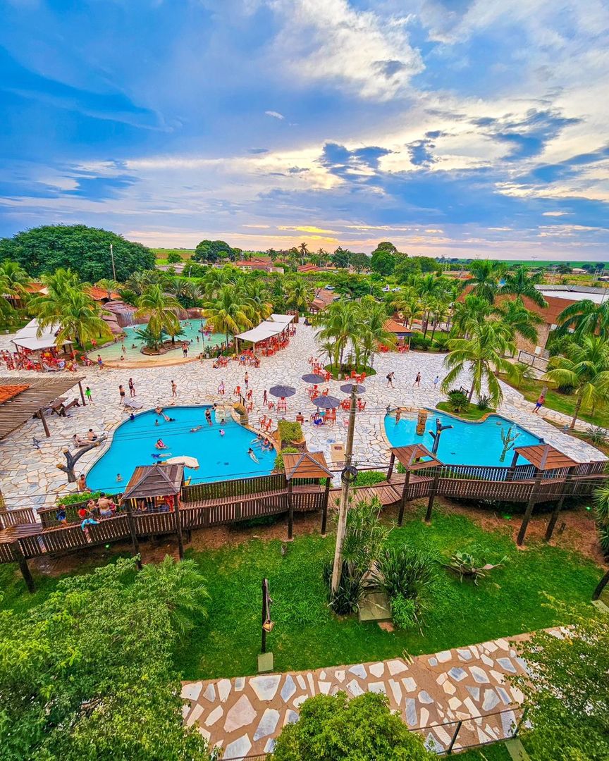 Resort em Barretos com parque aquático, piscinas e palmeiras ao entardecer